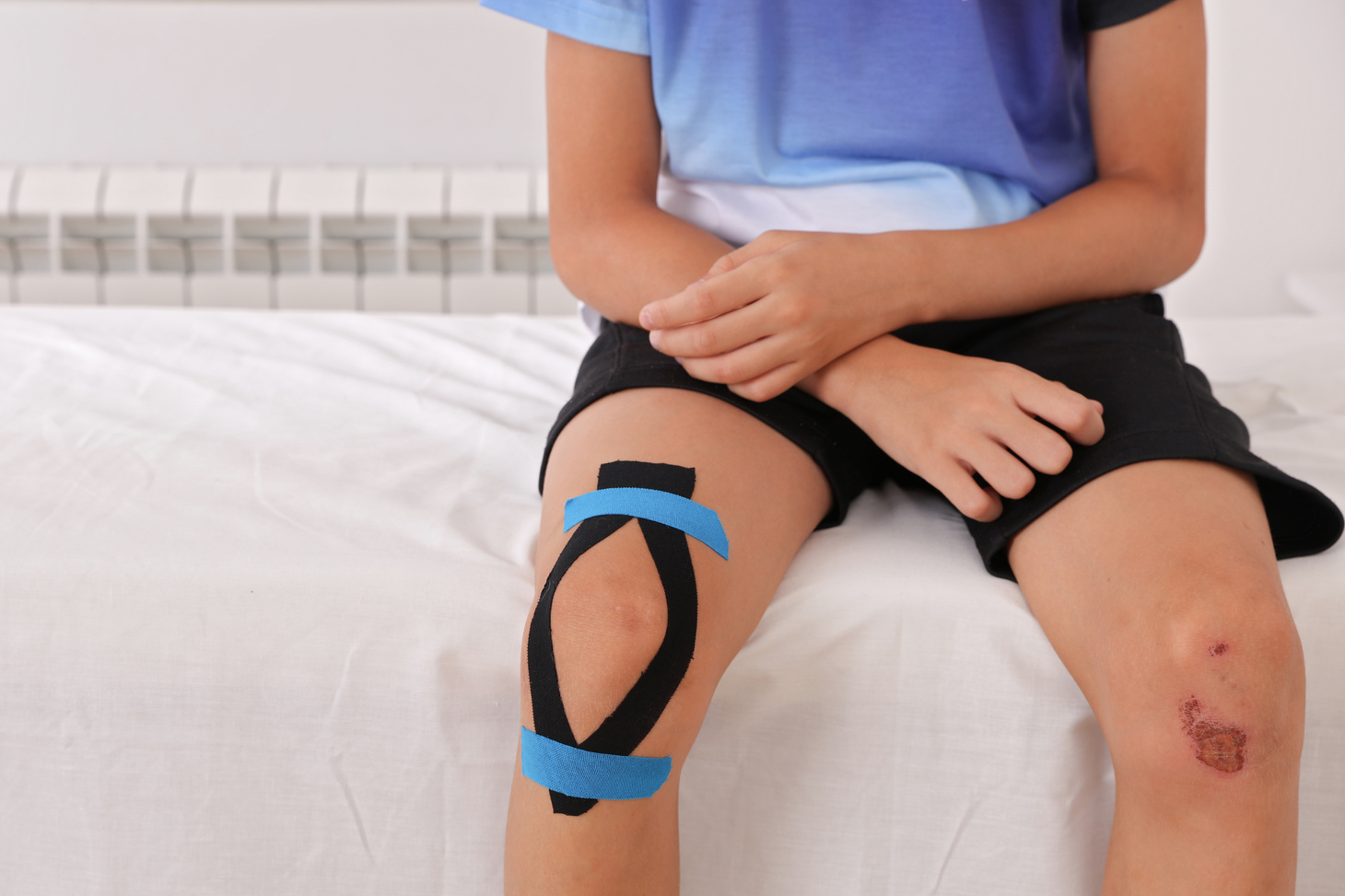Physiotherapy and Kinesiology taping for children. Teen sport Knee injuries treatment